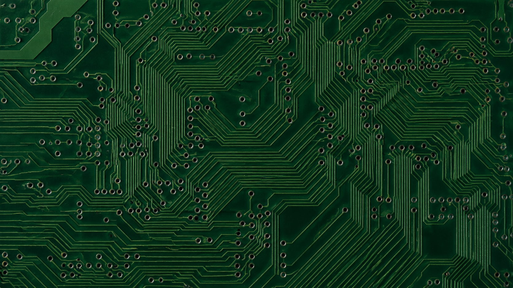 A close-up of copper traces and vias under green solder mask